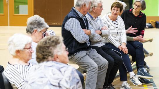 Ouderen zitten op een rij, klik voor een vergroting